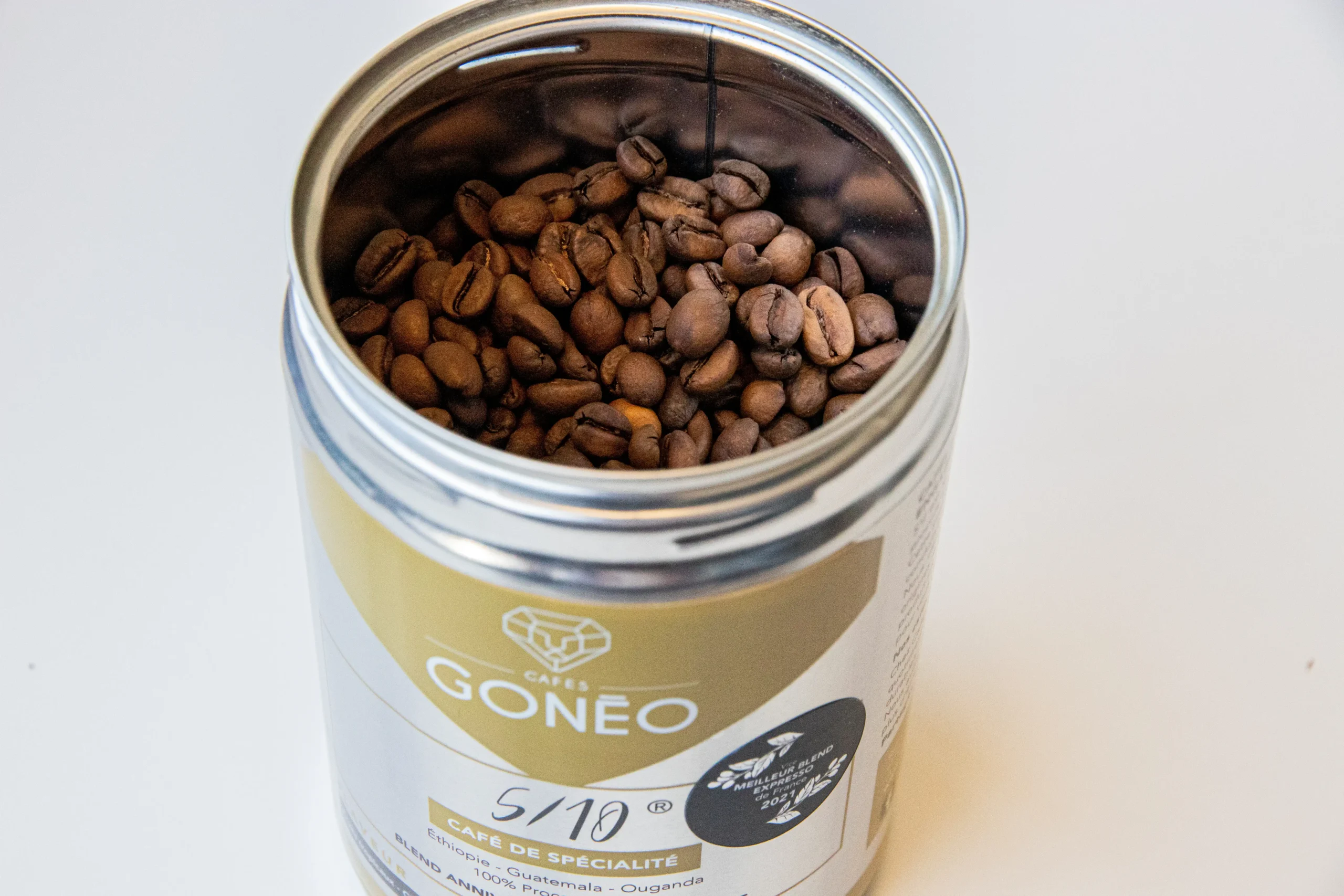 Boîte métallique ouverte du café-5/10®, café de spécialité, avec des grains de cafés à l'intérieur